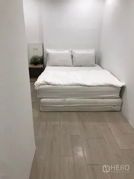 Home Office for rent - Compact bedroom with a white bed, light wood flooring and minimal décor.