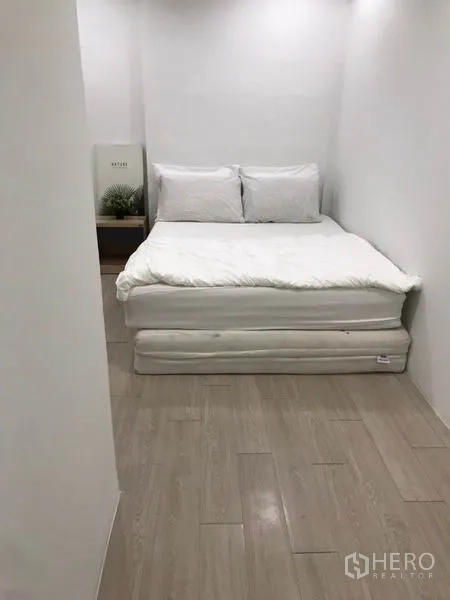Home Office for rent - Compact bedroom with a white bed, light wood flooring and minimal décor.