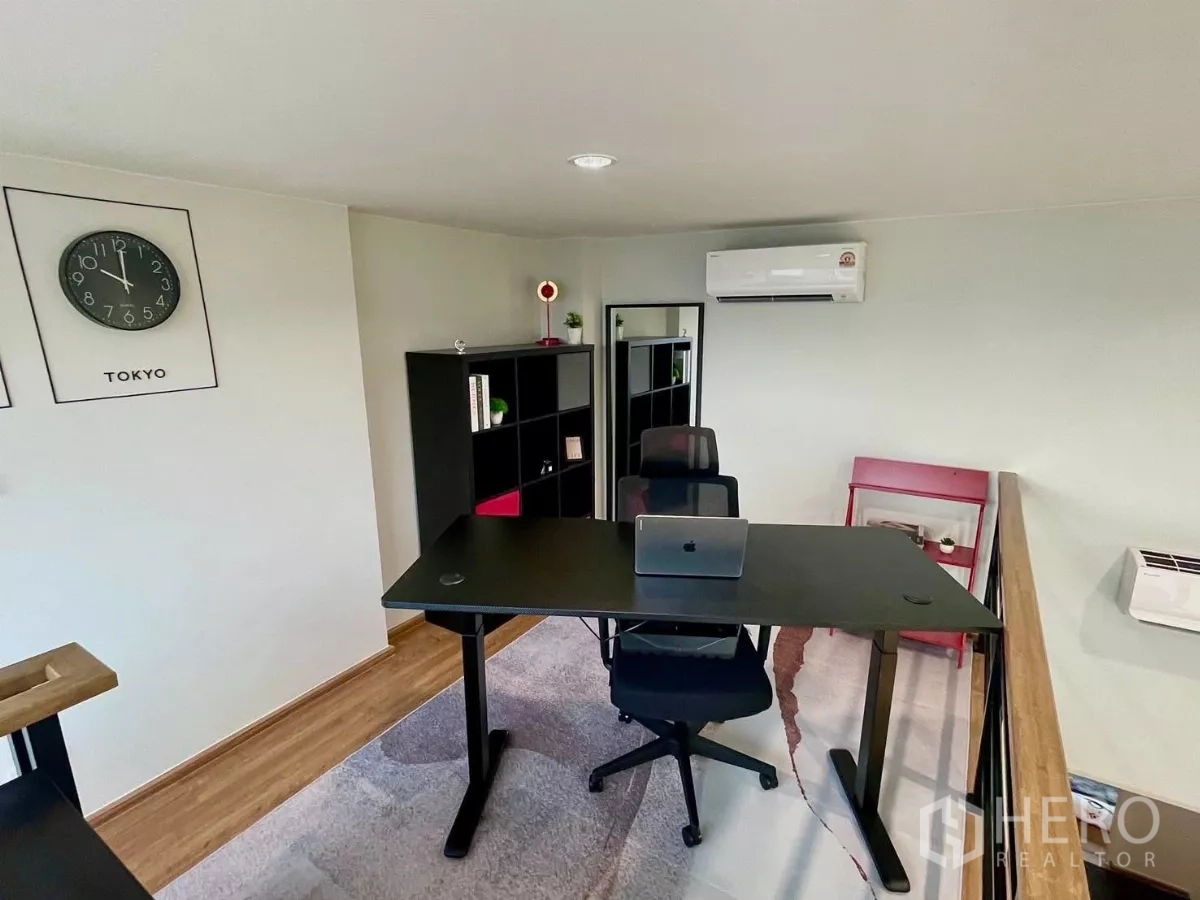Townhouse for rent in Samut Prakan - Loft home office with adjustable desk, ergonomic chair and shelving.