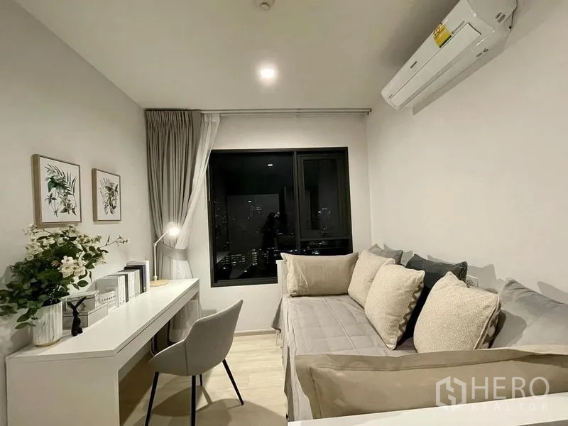 公寓 出租在Pathum Wan, Bangkok - 次卧或书房，设日间床、长书桌与窗外城市天际线。
