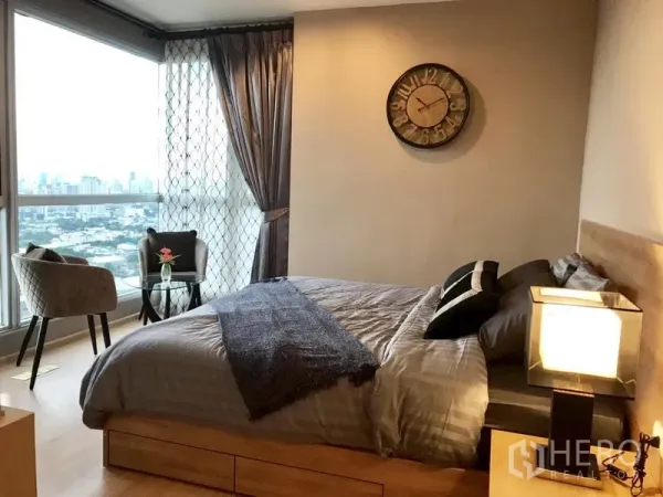 Condominium for rent in Khlong Toei, Bangkok - Bedroom with large corner windows, seating nook and expansive Bangkok skyline view.
