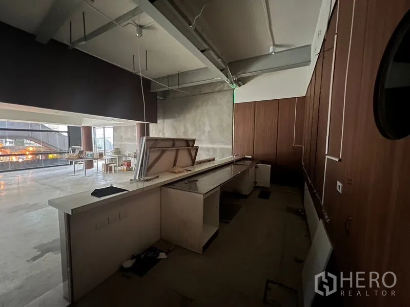 Retail Space for rent in Watthana, Bangkok - Long service counter and pantry area with wood wall panels and built-in cabinetry.