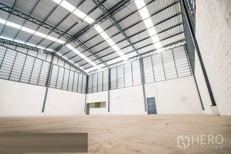 Warehouse for rent - High-ceiling warehouse with louvered walls and high-bay lighting.
