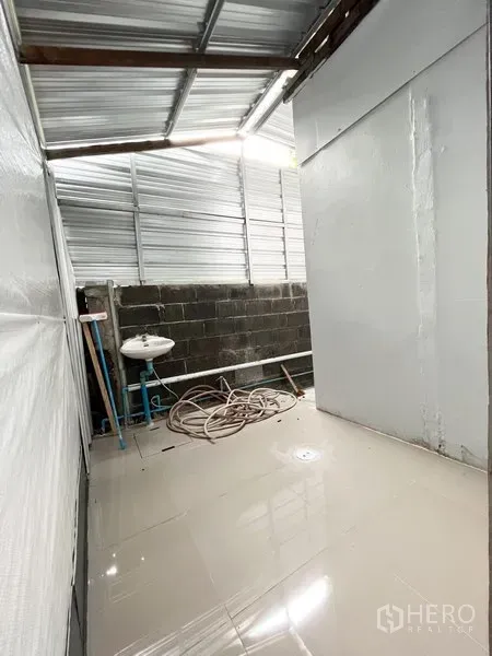 คลังสินค้า ให้เช่าในWang Thonglang, Bangkok - พื้นที่อเนกประสงค์มีอ่างล้างมือและสายยาง ใต้หลังคาเมทัลชีทข้างฮอลล์หลัก
