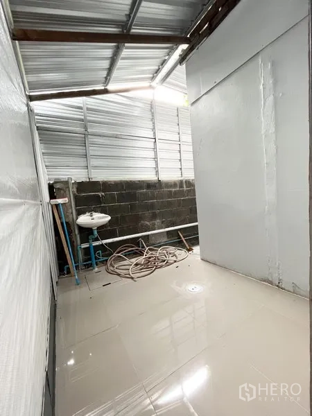 คลังสินค้า ให้เช่าในWang Thonglang, Bangkok - พื้นที่อเนกประสงค์มีอ่างล้างมือและสายยาง ใต้หลังคาเมทัลชีทข้างฮอลล์หลัก