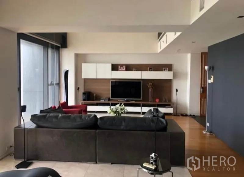 Condominium for rent in Sathon, Bangkok - Living area facing media wall and hardwood floors with natural light
