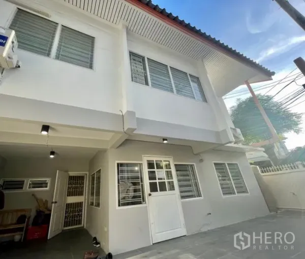 Townhouse for rent in Din Daeng, Bangkok - Two-storey Huai Khwang townhouse exterior with gated carport and white facade near MRT Sutthisan.