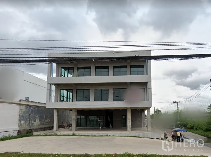 Home Office for rent in Lat Krabang, Bangkok - Three-storey modern home office with large windows and a wide concrete forecourt along a main road in Lat Krabang, Bangkok.