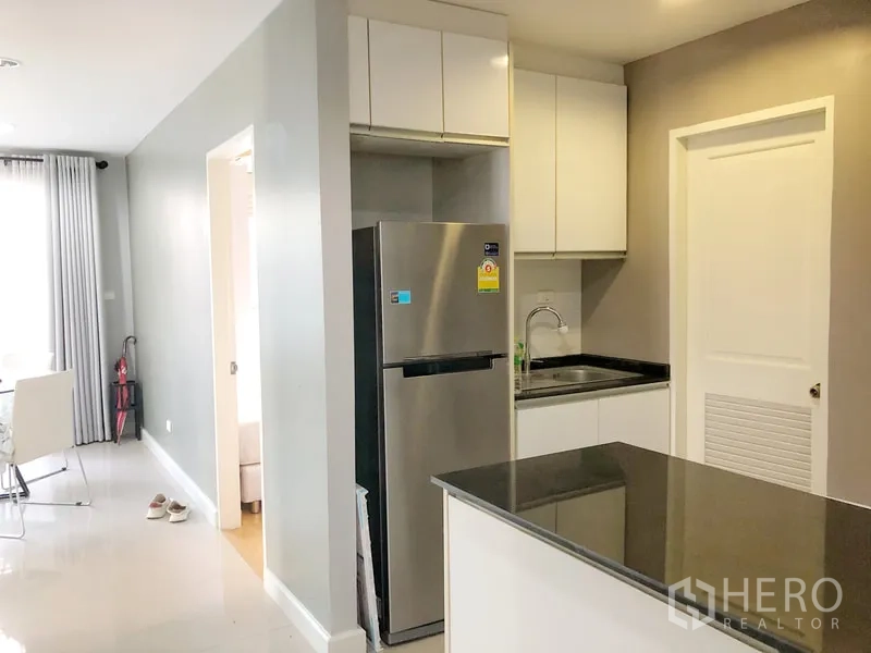 Condominium for rent or sale in Khlong Toei, Bangkok - Modern kitchen with stainless fridge, sink and ample storage.