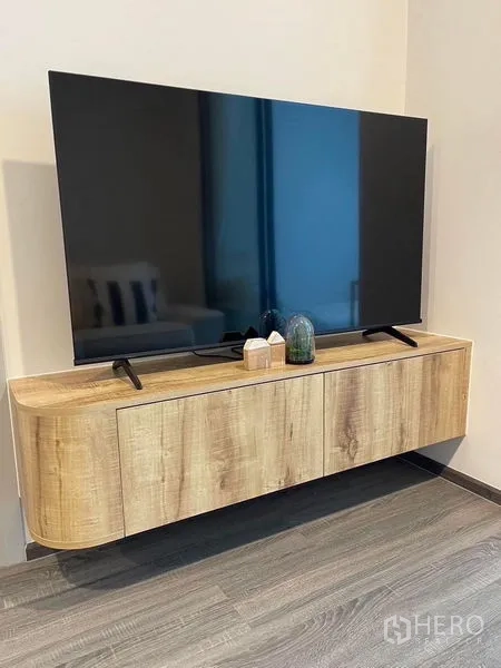 Condominium for rent - Large flat-screen TV on a floating wooden media console in a neutral-toned room.