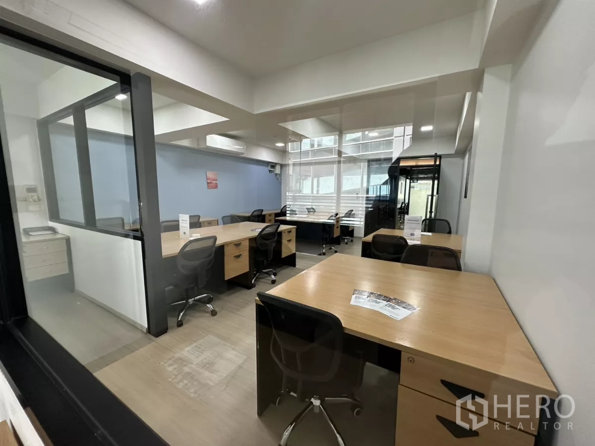 办公空间 出租在Watthana, Bangkok - 从独立房看向共享办公区，桌椅整齐，自然采光良好。