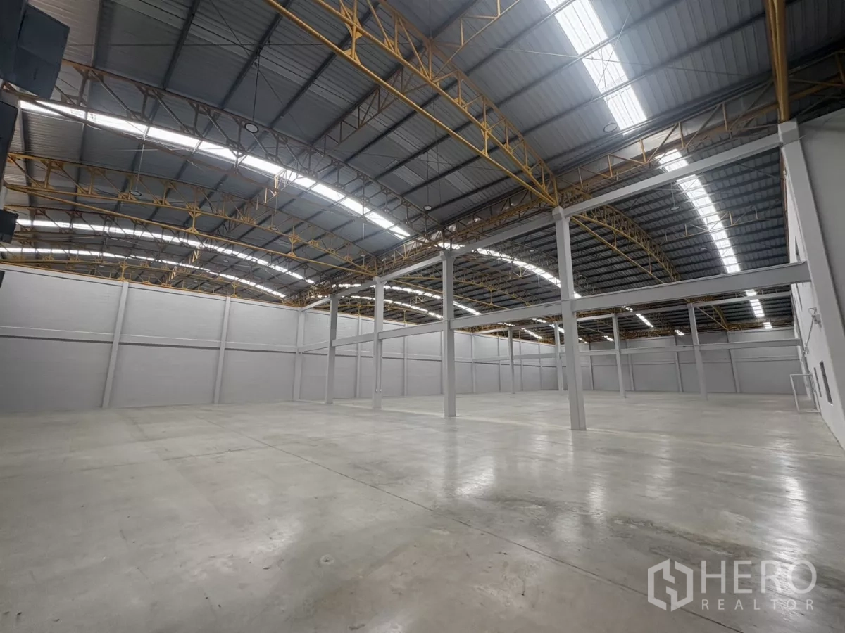 Factory for rent in Bang Phli, Samut Prakan - Warehouse interior showing skylights, steel trusses, and wide column spacing.
