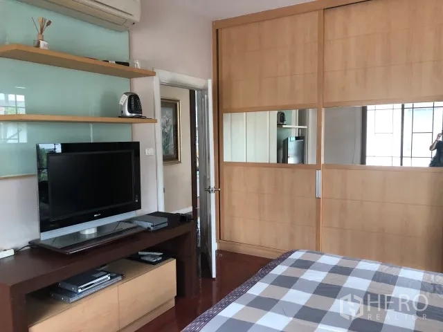 Detached House for rent in Bang Phli, Samut Prakan - Bedroom angle showing built-in sliding wardrobe, TV console and wall shelving.