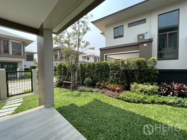 Detached House for rent in Bang Kapi, Bangkok - Landscaped front garden with hedge and a small patio under the porch.