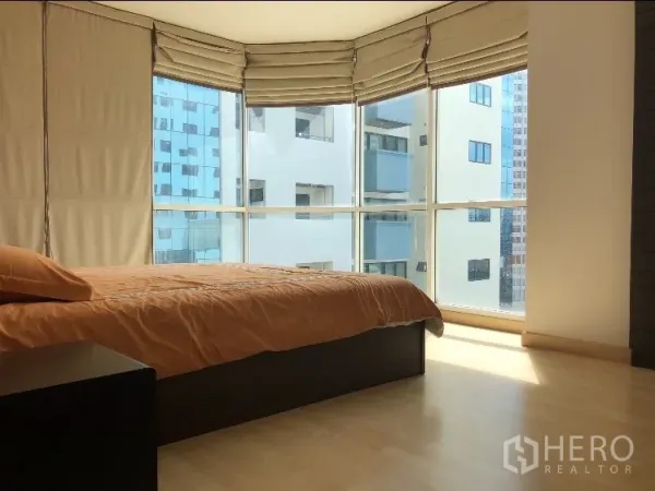公寓 出租在Watthana, Bangkok - 转角卧室，落地窗、罗马帘与浅色木地板。