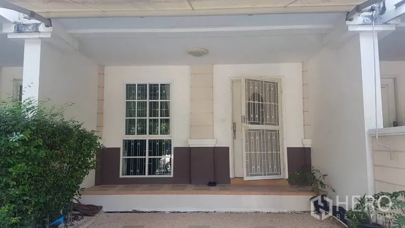 Townhouse for rent in Bang Kapi, Bangkok - Covered front porch with gated parking and white security doors.