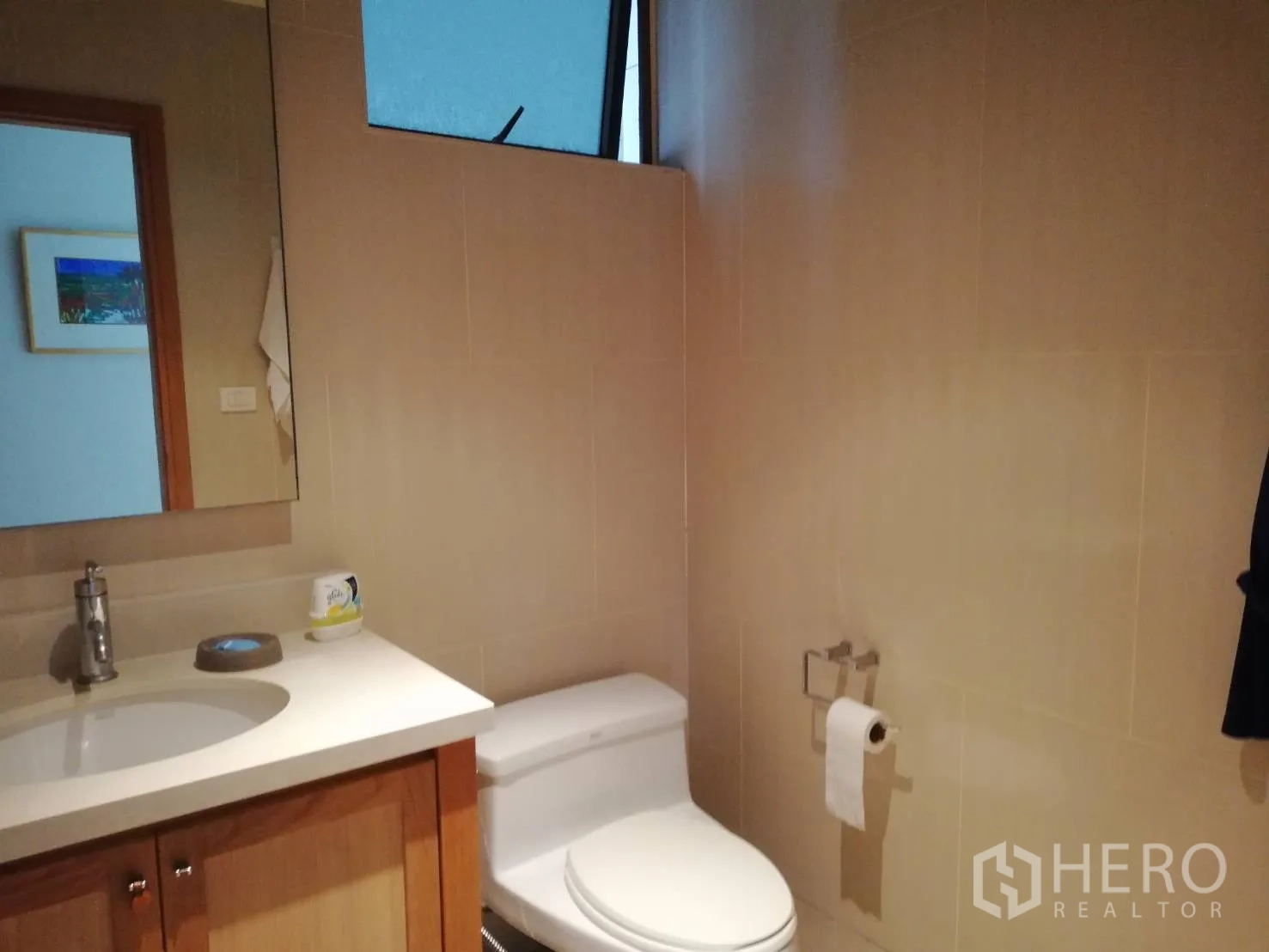 Condominium for sale in Khlong Toei, Bangkok - Guest bathroom with vanity, toilet and frosted window.
