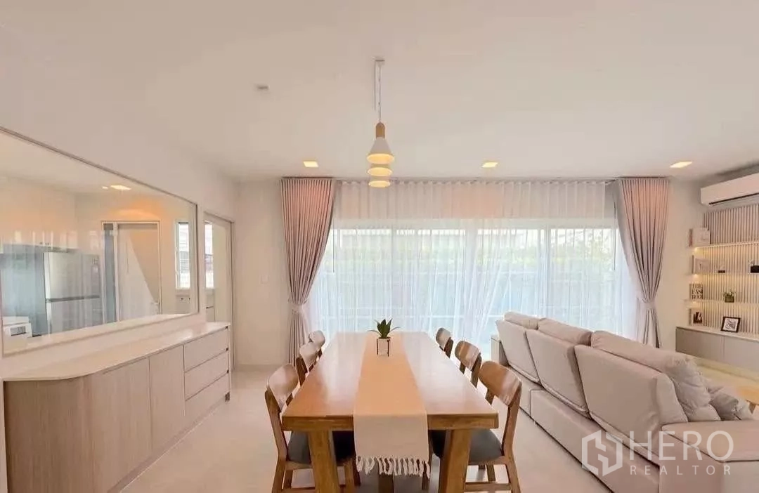 Detached House for rent or sale in Bang Phli, Samut Prakan - Dining and lounge space filled with natural light from corner glass walls.