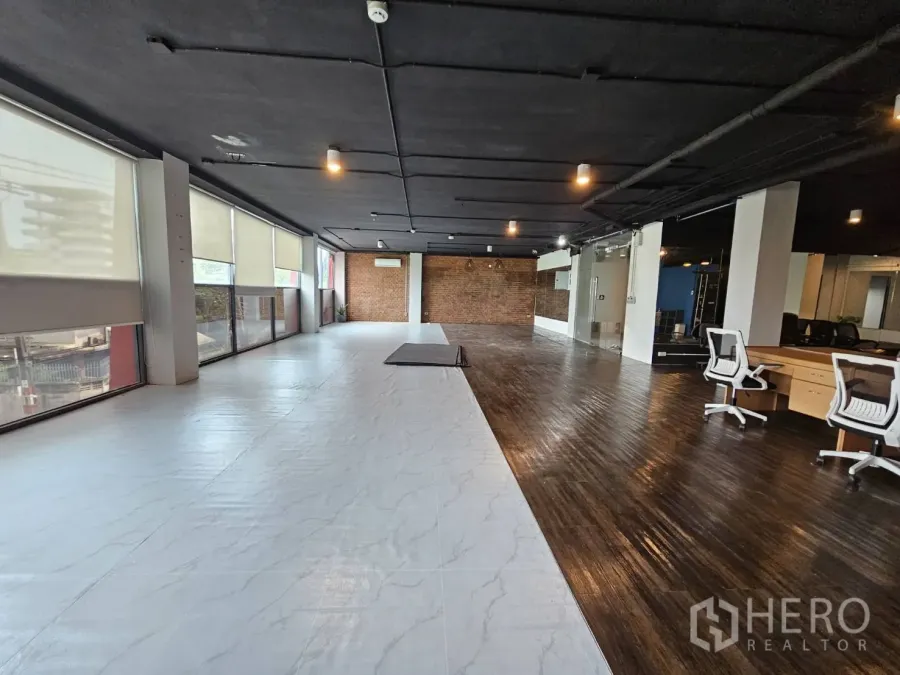 办公空间 出租在Watthana, Bangkok - 开放式办公室，长窗配百叶，白色与木质地面搭配，外露天花，并设玻璃会议室。