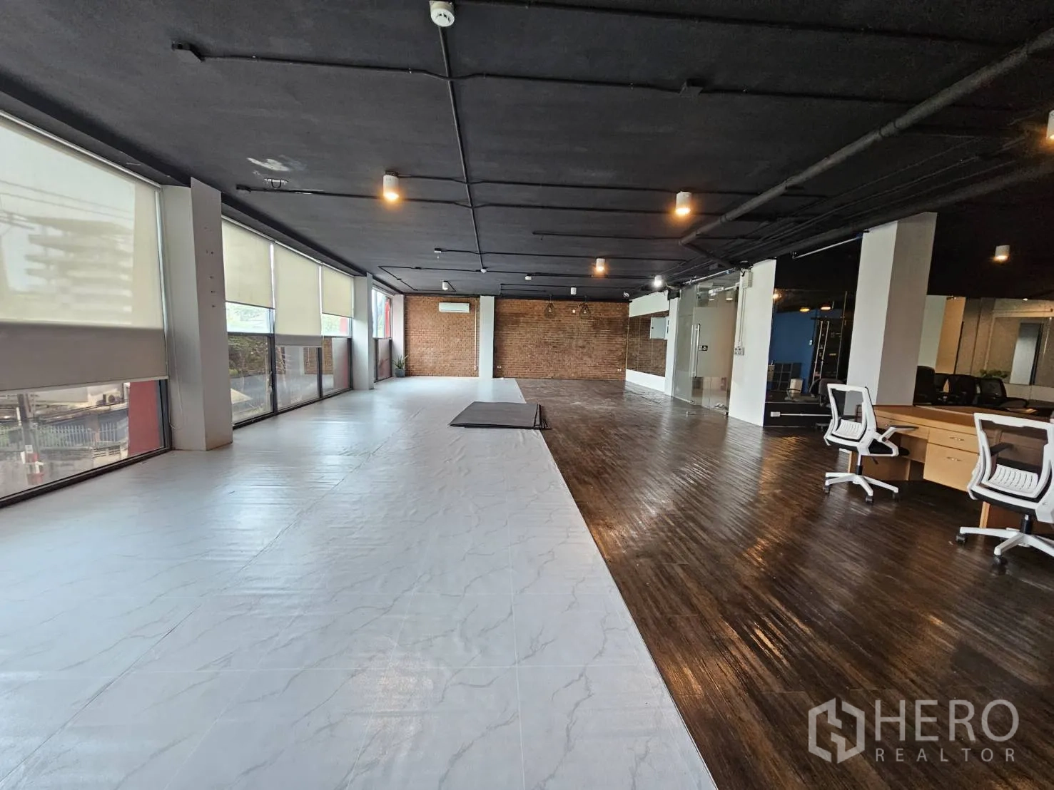办公空间 出租在Watthana, Bangkok - 开放式办公室，长窗配百叶，白色与木质地面搭配，外露天花，并设玻璃会议室。