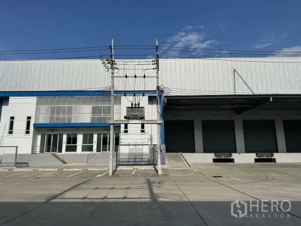 Factory for rent in Bang Sao Thong, Samut Prakan - Front elevation showing office block, transformer, and multiple dock-high roller shutters.