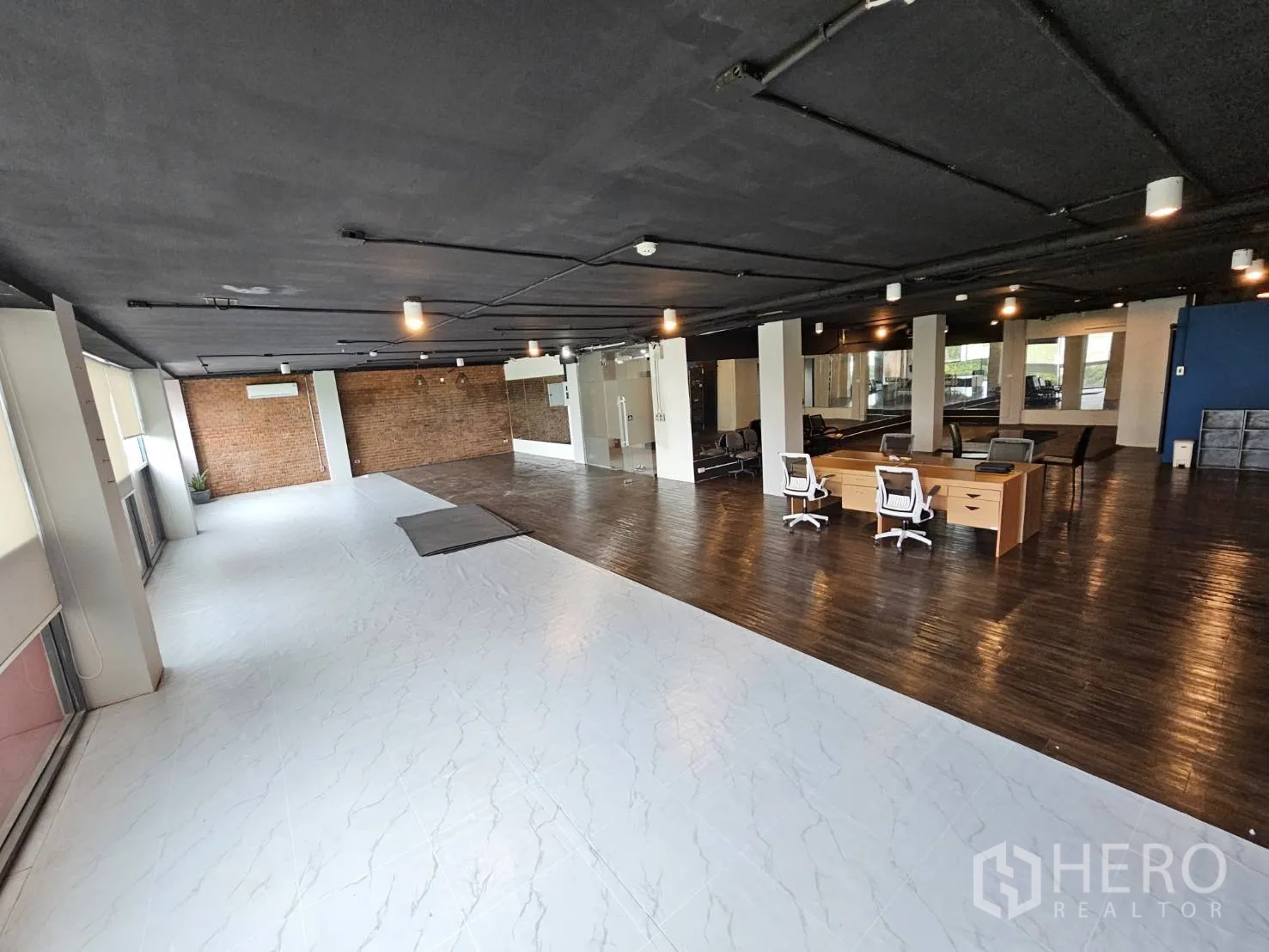 办公空间 出租在Watthana, Bangkok - 明亮办公区，白色地砖区、砖墙背景、办公桌与长窗百叶。