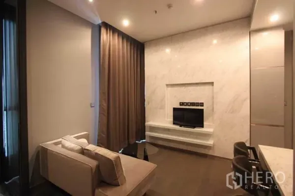 公寓 出租在Huai Khwang, Bangkok - 客厅设大理石电视墙、沙发与窗帘，毗邻吧台厨房。