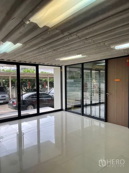 Factory for rent in Mueang Samut Prakan, Samut Prakan - Sunlit office with floor‑to‑ceiling windows and glossy tiles