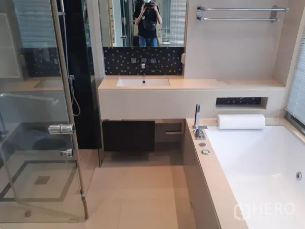 Condominium for rent in Khlong Toei, Bangkok - Modern bathroom with wide vanity, soaking bathtub and window.
