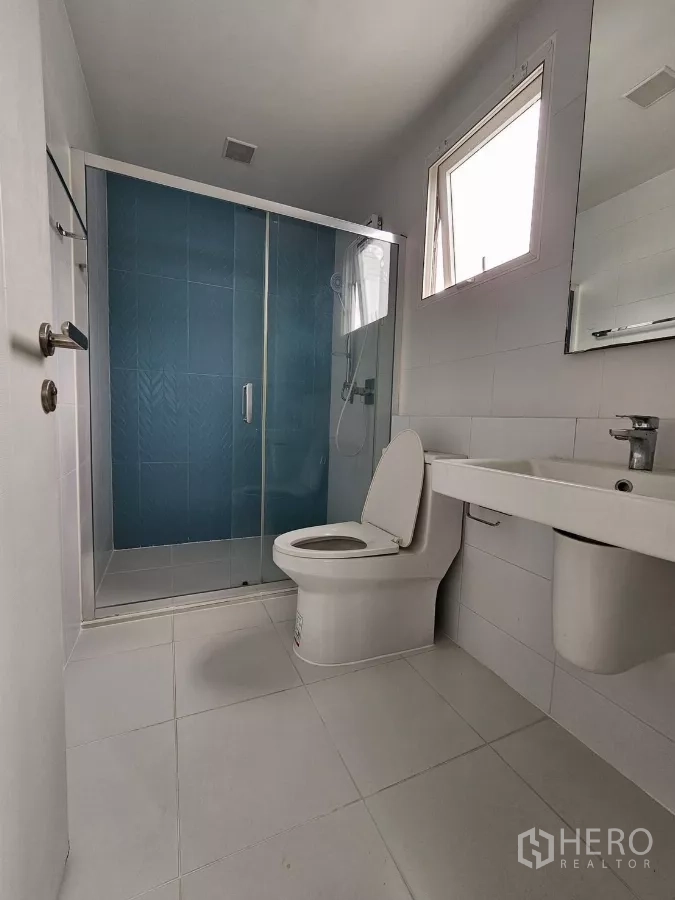 独立式住宅 出租在Prawet, Bangkok - 套内卫浴，蓝色瓷砖淋浴房与玻璃门
