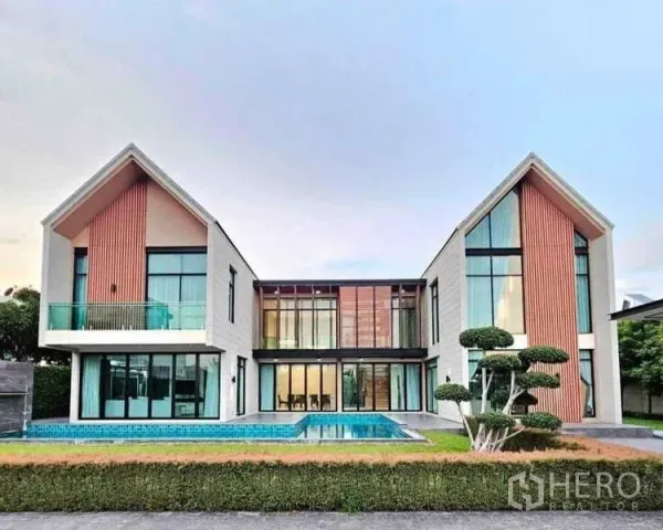独立式住宅 出售在Khlong Sam Wa, Bangkok - 别墅正立面，双人字形屋顶、通高玻璃与私家泳池。
