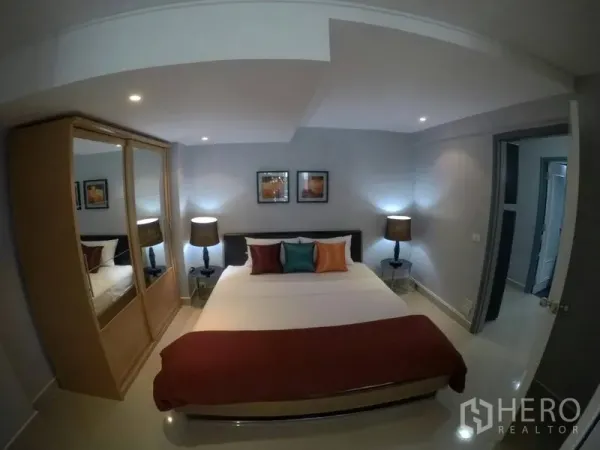 Condominium for rent in Watthana, Bangkok - Cozy master bedroom with king bed, mirrored wardrobe and soft bedside lighting.