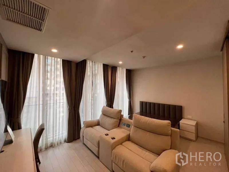 公寓 出租在Pathum Wan, Bangkok - 开阔客厅与睡眠区，双躺椅、床铺与环绕落地窗