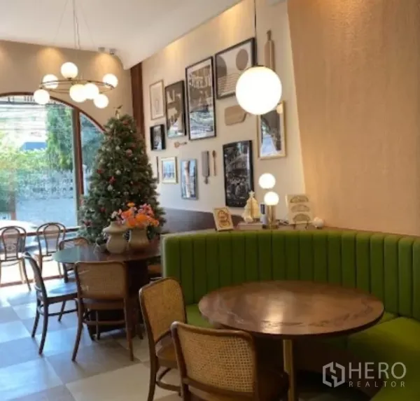 Retail Space for rent in Watthana, Bangkok - Cozy seating with green banquette, round wood tables, and a gallery wall.
