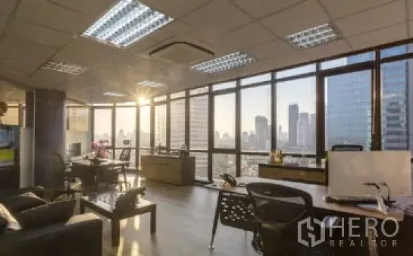 Office Space for rent in Khlong Toei, Bangkok - Bright open-plan office with floor-to-ceiling windows, sunset city skyline views, wood floors, desks and ceiling AC.