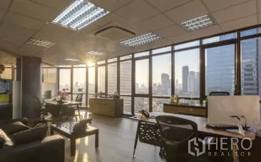 办公空间 出租在Khlong Toei, Bangkok - 明亮开放式办公室，落地窗与日落城景，木地板、办公桌与吊顶空调。