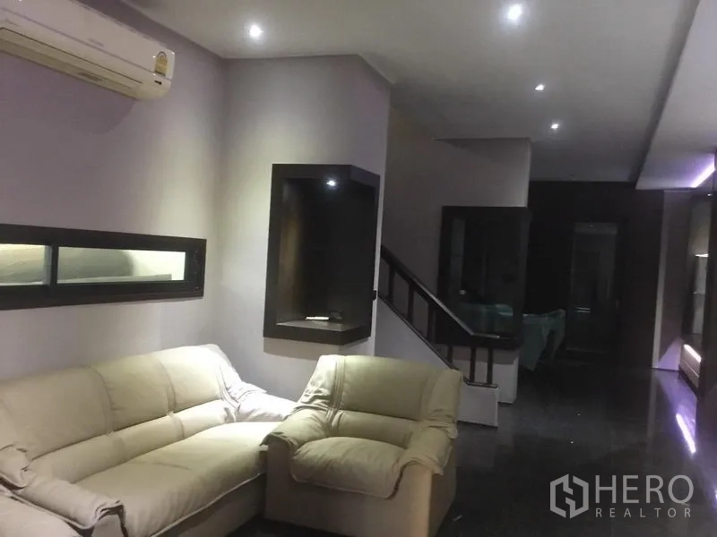 带办公室的家 出租在Suan Luang, Bangkok - 客厅区设沙发、楼梯与嵌入式筒灯。