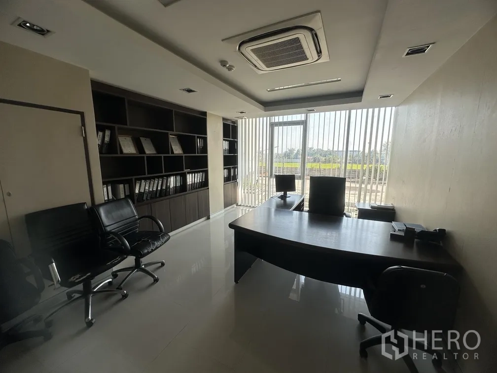工厂 for rent in Lam Luk Ka, Pathum Thani - 经理办公室，带书架、办公桌与百叶窗外景。