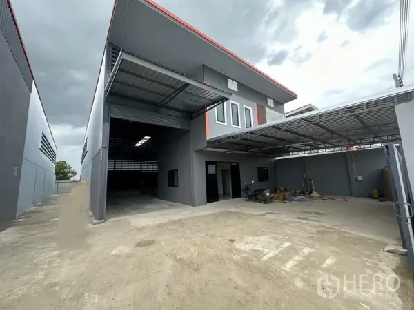 货栈 出租在Lam Luk Ka, Pathum Thani - 宽阔车道与带顶装卸区，卷帘门和办公室窗户