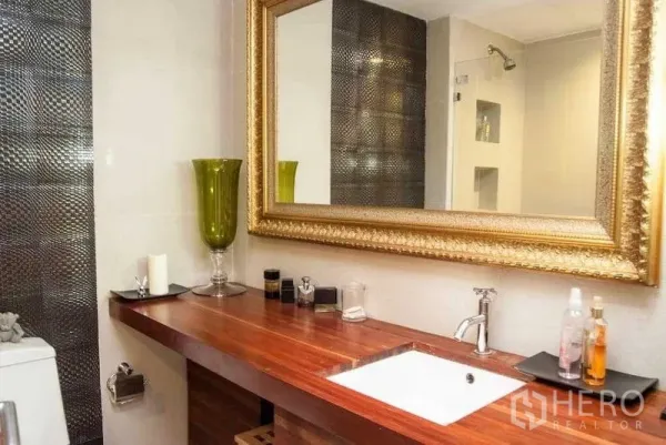 คอนโด ให้เช่าในWatthana, Bangkok - ห้องน้ำเคาน์เตอร์ไม้ยาว อ่างล้างหน้า กระจกกรอบทอง และผนังไทล์ลายเท็กซ์เจอร์