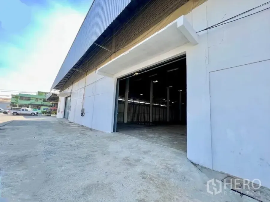 货栈 出租在Pak Kret, Nonthaburi - 仓库外部：宽阔装卸区与卷闸门，混凝土车道直通街面。