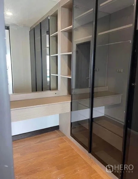 Condominium for rent - Walk-in closet featuring glass-front wardrobes and a dressing table.