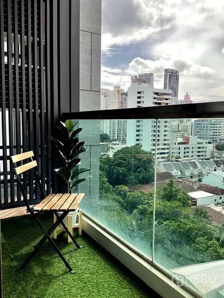 Condominium for rent or sale - Private balcony with a chair, glass railing and city skyline view near Phrom Phong.