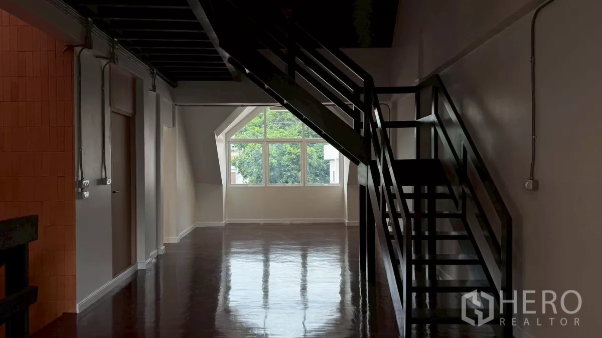 Home Office for rent in Watthana, Bangkok - Loft-style upper floor with metal staircase and gable window outlook.