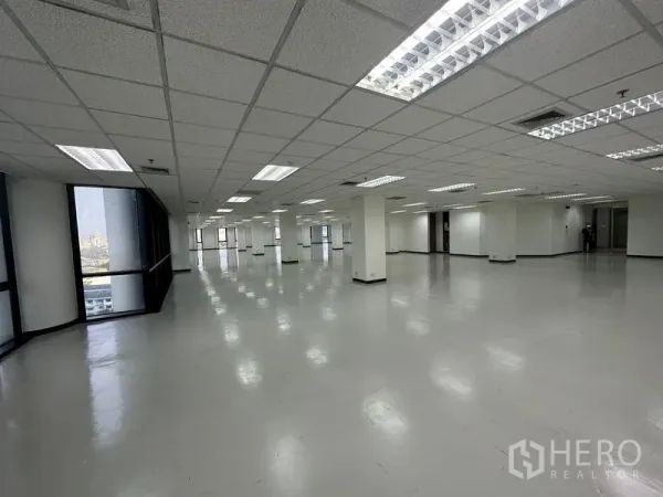 办公空间 出租 - 开放式大办公楼层，格栅吊顶与筒灯，柱网整齐，转角大窗可看城市景观。