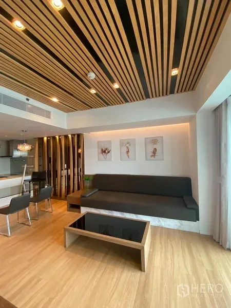 公寓 出租在Yan Nawa, Bangkok - 现代起居区，木格栅天花，内置沙发与茶几，落地窗采光充足。