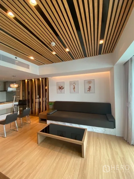 公寓 出租在Yan Nawa, Bangkok - 现代起居区，木格栅天花，内置沙发与茶几，落地窗采光充足。