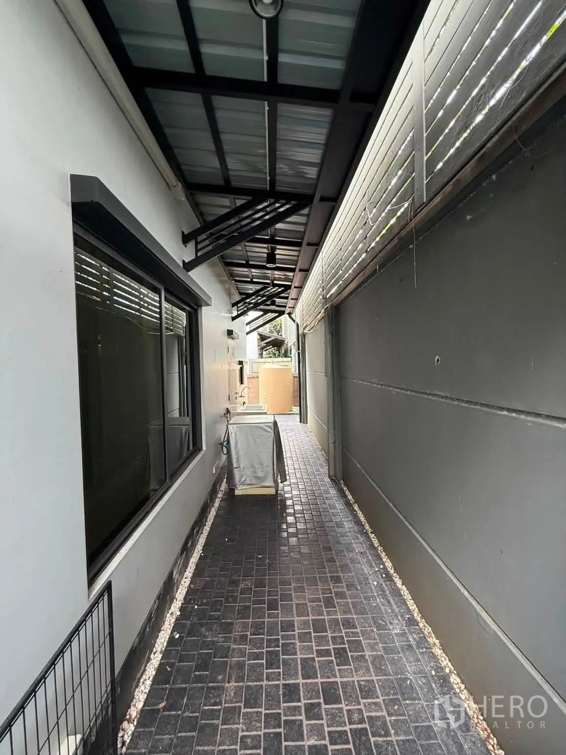 Detached House for rent in Bang Kapi, Bangkok - Covered side walkway with black tiled path beside the house.