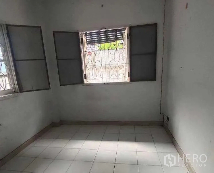 独立式住宅 出售在Phra Khanong, Bangkok - 小型瓷砖房间，窗设护栏，适合作为工人房或杂物间，需更新。