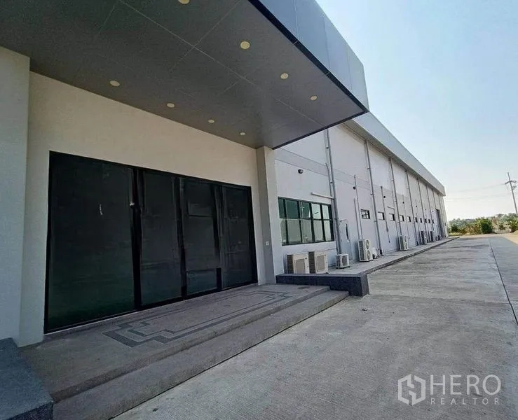 Warehouse for rent or sale in Pathum Thani - Shaded loading entrance and side elevation of the warehouse with ample parking apron.